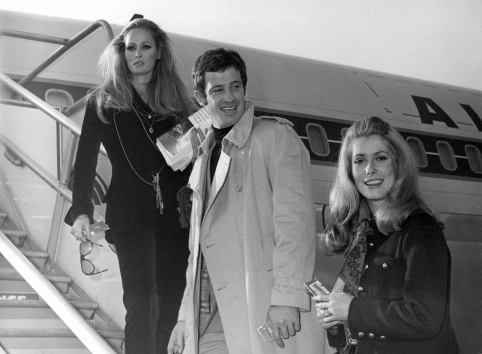 FILE - In this Nov. 29, 1968 file photo, actress Ursula Andress, left, joins Jean-Paul Belmondo, center, and Catherine Deneuve, right, on the gangway of the plane in Orly airport, France. French New Wave actor Jean-Paul Belmondo has died, according to his lawyer’s office on Monday Sept. 6, 2021. (AP Photo/File)