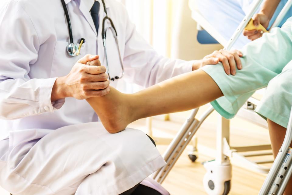 An orthopedic surgeon checks a patient's joint pain.