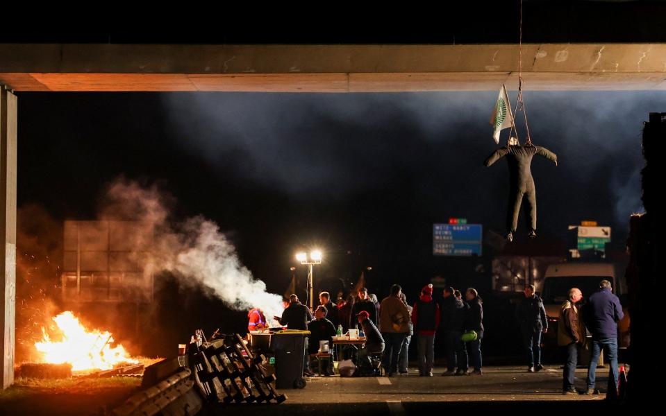 Protesters hang an effigy as they gather during a blockade on the A4 near Paris on Monday night