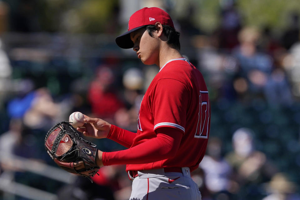 Los Angeles Angels pitcher Shohei Ohtani looks at the baseball after a pitch against the Oakland Athletics during the first inning of a spring training baseball game, Friday, March 5, 2021, in Mesa, Ariz. (AP Photo/Matt York)