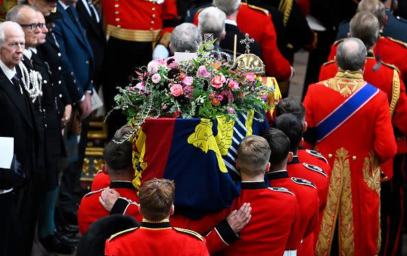 LONDON, ENGLAND - SEPTEMBER 19: The coffin of Queen Elizabeth II with the Imperial State Crown resting on top is carried by the Bearer Party into Westminster Abbey during the State Funeral of Queen Elizabeth II on September 19, 2022 in London, England. Elizabeth Alexandra Mary Windsor was born in Bruton Street, Mayfair, London on 21 April 1926. She married Prince Philip in 1947 and ascended the throne of the United Kingdom and Commonwealth on 6 February 1952 after the death of her Father, King George VI. Queen Elizabeth II died at Balmoral Castle in Scotland on September 8, 2022, and is succeeded by her eldest son, King Charles III.  (Photo by Gareth Cattermole/Getty Images)