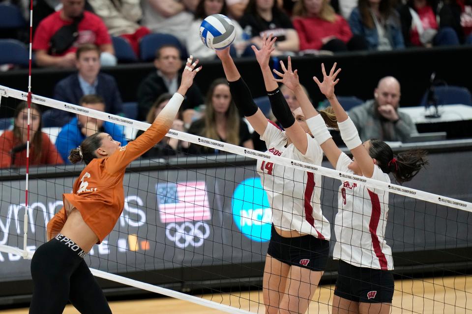 Wisconsin's Anna Smrek (14) and Caroline Crawford (9) block a shot by Texas's Madisen Skinner (6) during a semifinal match in the NCAA Division I women's college volleyball tournament Thursday, Dec. 14, 2023, in Tampa, Fla. (AP Photo/Chris O'Meara)