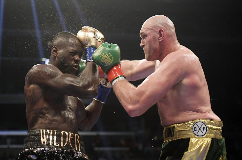 FILE - In this Dec. 1, 2018, file photo, Tyson Fury, right, of England, connects with Deontay Wilder during a WBC heavyweight championship boxing match in Los Angeles. Wilder is still frustrated by the way he fought in his draw with Fury. The WBC heavyweight champion watched a replay of the fight for the first time Thursday, Dec. 6, 2018, and saw things he did incorrectly. (AP Photo/Mark J. Terrill, File)