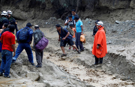 Residents try to cross a mudslide near the Central Highway after the Rimac river overflowed in Huarochiri, Lima, Peru, March 23, 2017. REUTERS/Guadalupe Pardo