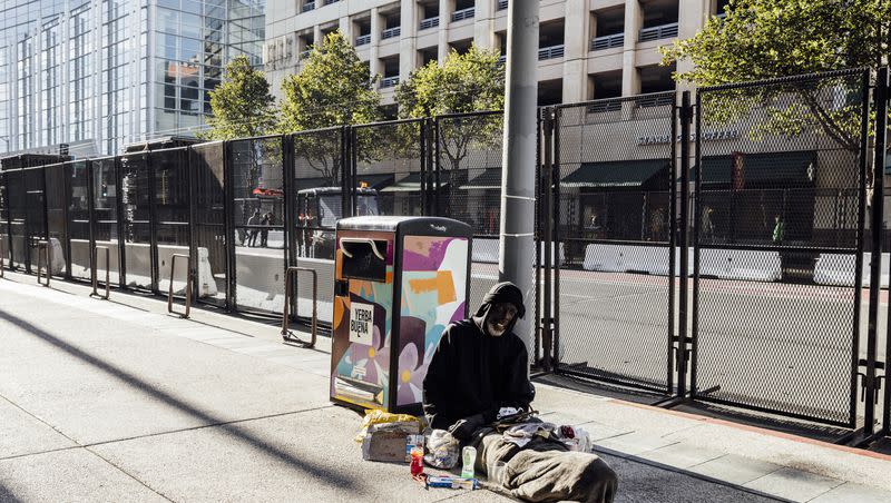 Tony Phillips, who’s been unhoused for eight years, rests near a security fence on Fourth Street ahead of the 2023 Asia-Pacific Economic Cooperation Economic Leaders’ Week in San Francisco on Nov. 11, 2023.