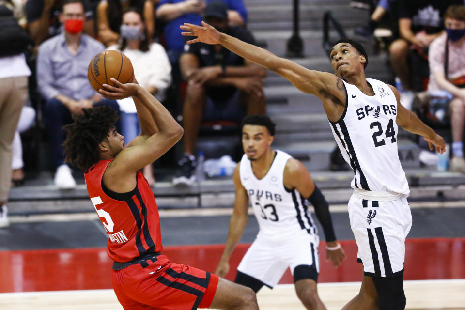Chicago Bulls' Ethan Thompson, left, shoots as San Antonio Spurs' Devin Vassell defends during the first half of an NBA summer league basketball game Tuesday, Aug. 10, 2021, in Las Vegas. (AP Photo/Chase Stevens)