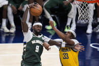Milwaukee Bucks forward Bobby Portis (9) grabs a rebound in front of Indiana Pacers center Myles Turner (33) during the second half in Game 2 in an NBA basketball first-round playoff series, Friday, April 26, 2024, in Indianapolis. (AP Photo/Michael Conroy)