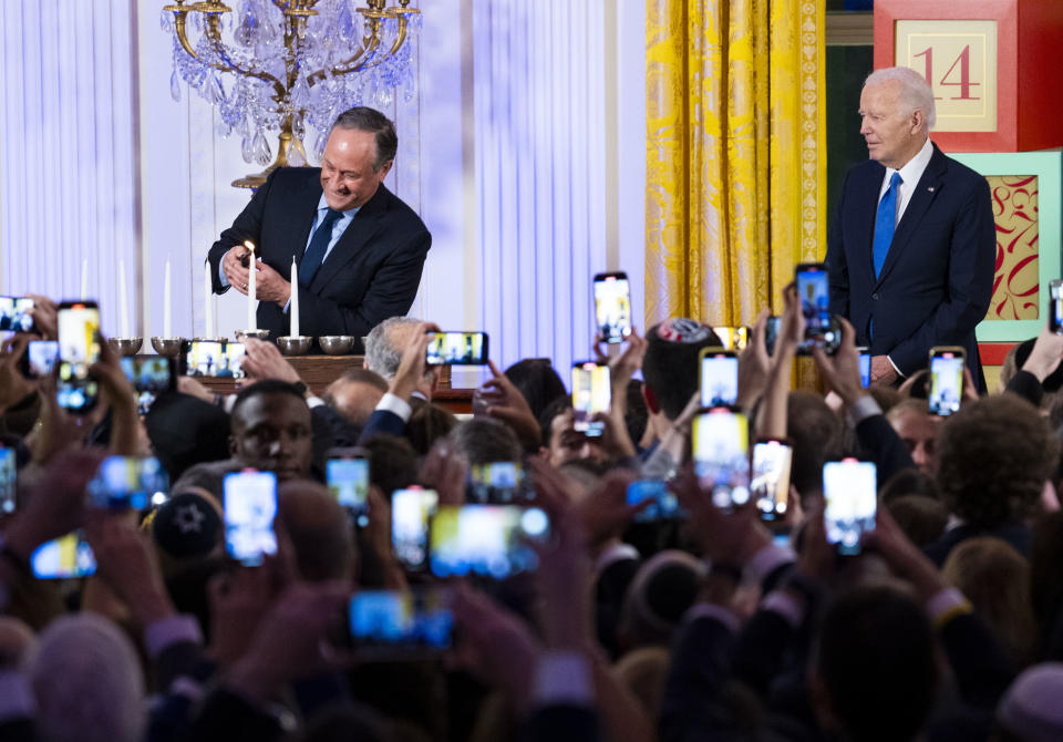 President Joe Biden looks on as Second Gentleman Douglas Emhoff lights the menorah during a Hanukkah reception this month in the East Room of the White House.