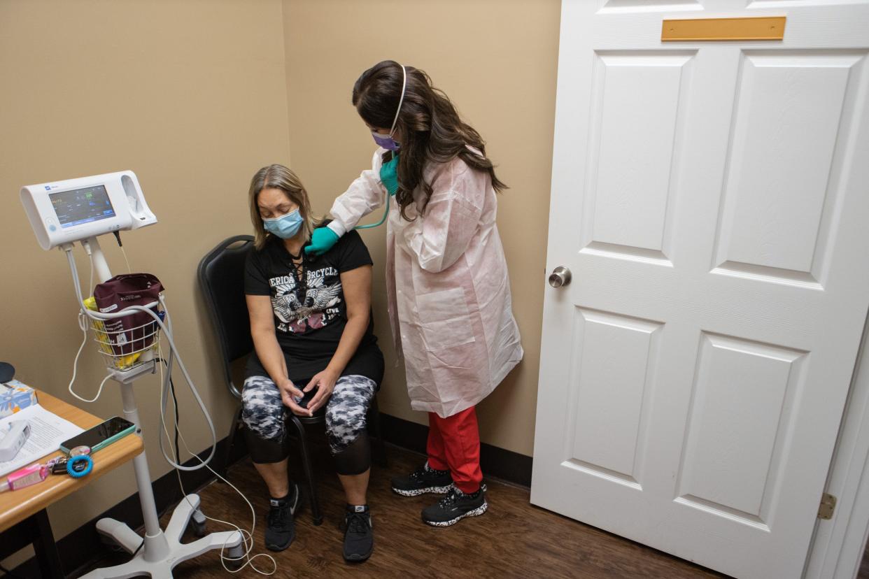 Nurse practitioner Katie Cornett, right, checks the lungs of patient Vickie Slone at a Primary Care Centers of Eastern Kentucky location in Hazard, Ky. Sept. 20, 2021