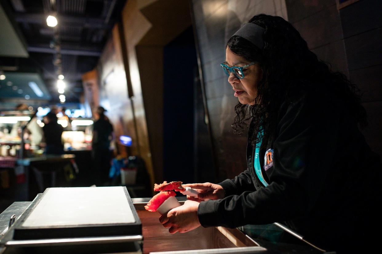 Annette Hill, Detroit Water Ice Factory director of store operation, prepares a cup of Tigers Blood with strawberry, coconut and watermelon flavors during the ÒWhatÕs NewÓ media event at Motor City Casino Tiger Club of Comerica Park in Detroit on Wednesday, March 27, 2024.