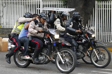 National police transport an anti-government protester detainee during a protest against Nicolas Maduro's government in Caracas March 13, 2014. REUTERS/Carlos Garcia Rawlins