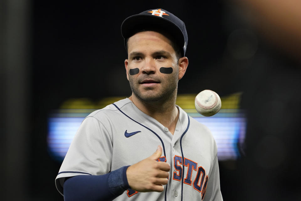 Houston Astros second baseman Jose Altuve tosses a baseball as he walks off the field after the sixth inning of a baseball game against the Seattle Mariners, Monday, July 26, 2021, in Seattle. (AP Photo/Ted S. Warren)