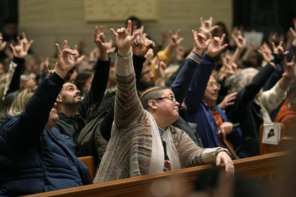 Mourners sign "I love you" at a vigil for the victims of Wednesday's mass shootings at the Basilica of Saints Peter and Paul, Sunday, Oct. 29, 2023, in Lewiston, Maine. (AP Photo/Robert F. Bukaty)