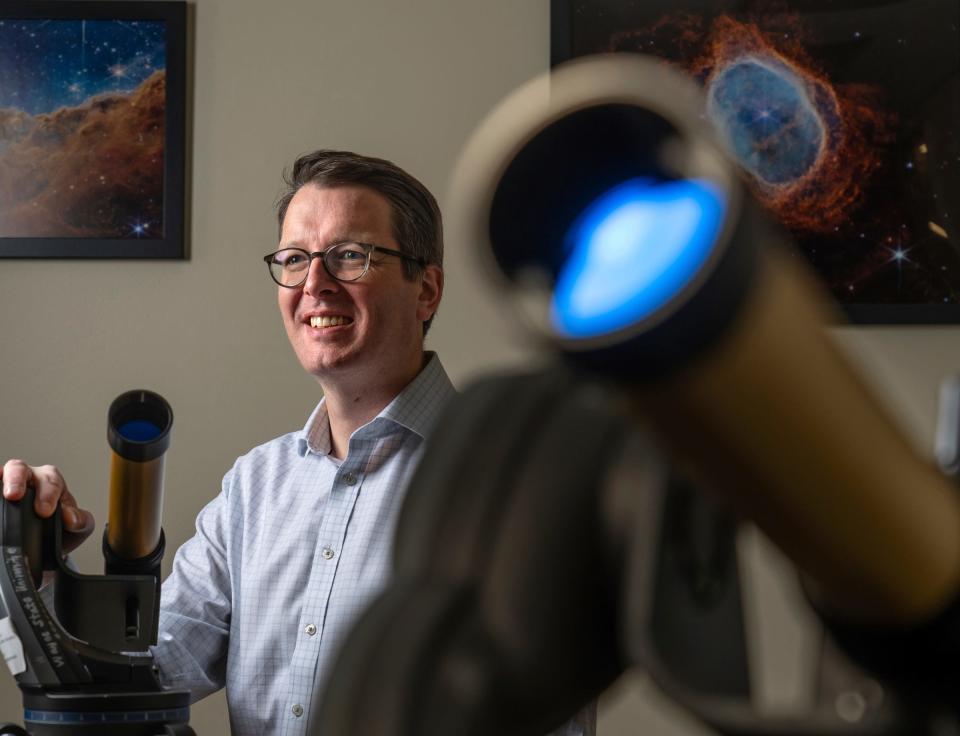 Wayne State University department of physics and astronomy professor and chair Ed Cackett sits with solar telescopes in his office at the Detroit campus on Friday, March 22, 2024.