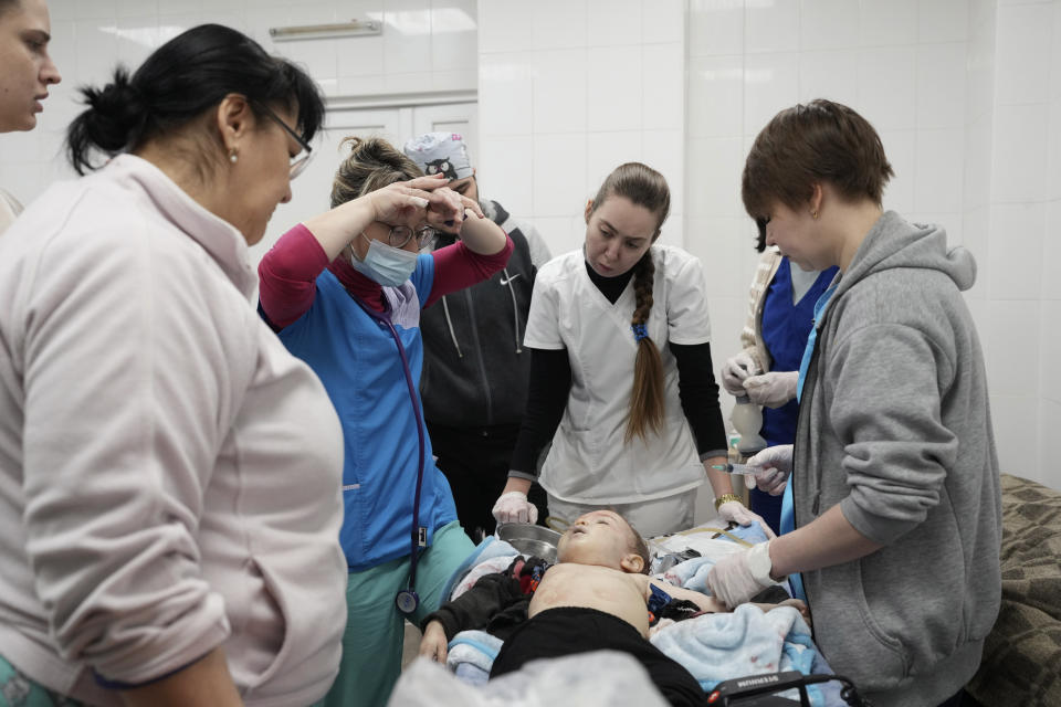 Medical workers react as they try to save the life of Marina Yatsko's 18 month-old son Kirill, who was fatally wounded by shelling, at a hospital in Mariupol, Ukraine, Friday, March 4, 2022. (AP Photo/Evgeniy Maloletka)
