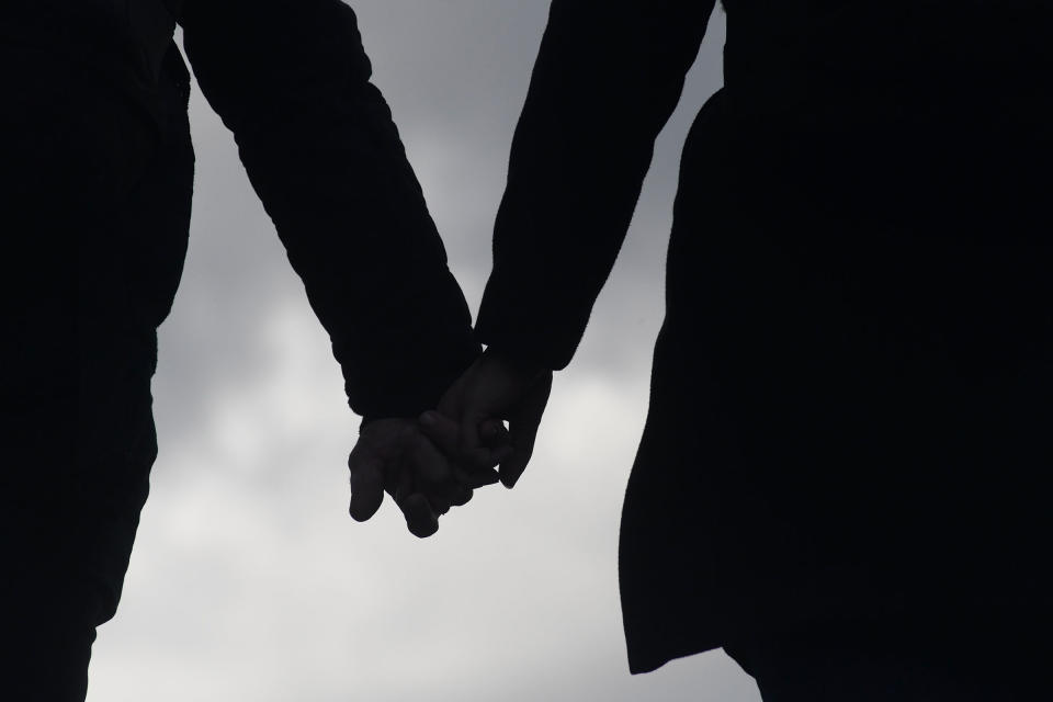 A silhouette of two people holding hands