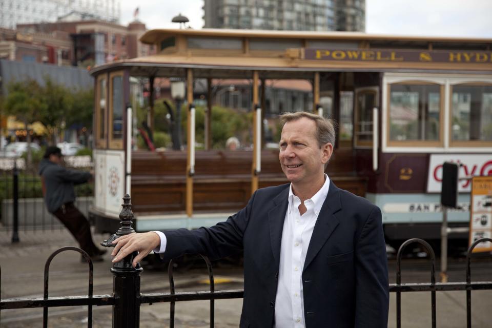 In this photo taken Thursday, Oct. 25, 2012, Michael Ellis, the new worldwide director of Michelin Guide, poses by the Hyde Street cable car turnaround and Ghirardelli Square near Fisherman's Wharf in San Francisco. Ellis took over this year as head of the guides, becoming the first U.S.-born (and first non-Frenchman) to head the Michelin Guide. (AP Photo/Eric Risberg)