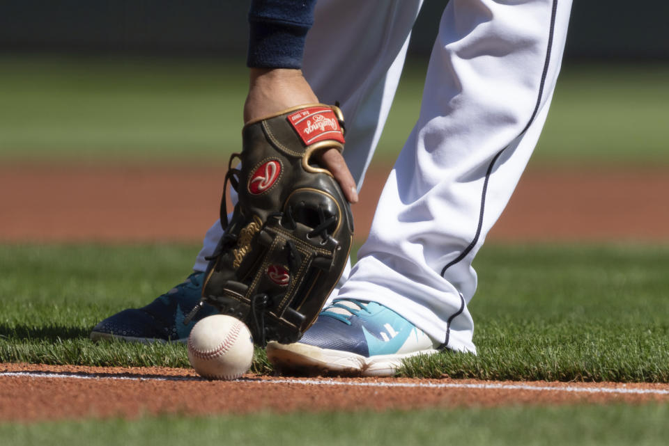 Seattle Mariners third baseman Eugenio Suarez recovers the ball after an infield hit by Cleveland Guardians' Amed Rosario during the first inning of baseball game, Thursday, Aug. 25, 2022, in Seattle. (AP Photo/Stephen Brashear)