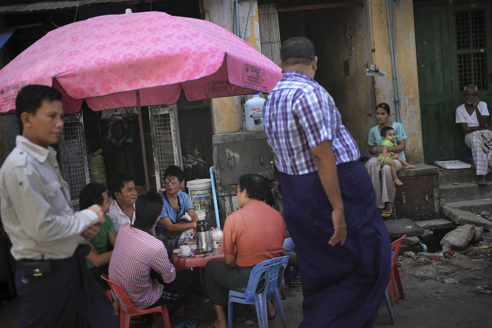 In this Tuesday, Aug. 13, 2013 photo, Kyaw Htoo, center in blue, one of Myanmar's best-known comedians sits and drinks tea with his friends as he waits for work in downtown Yangon, Myanmar. Myanmar's movie industry is organized in a unique way. Actors and actresses congregate - form unions, develop health-care plans, lobby for benefits - based on the roles they play on screen. There is an aging mothers' guild, a spinsters' guild, a comedians' guild. It is typecasting, pulled into the real world. These days, in the hierarchy of movie roles, comedians seem to fare better. Perhaps because Myanmar is hungry for laughter, not villainy, most movies made inside the country these days are comedies. Thus, those who make people smile are higher on the food chain. This is of no small import to the villains, befuddled by a world where the jokester outpaces the scoundrel. (AP Photo/Wong Maye-E)