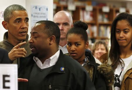 U.S. President Barack Obama (L) and his daughters Sasha and Malia (R) shop at Politics and Prose bookstore in Washington November 29, 2014. REUTERS/Yuri Gripas