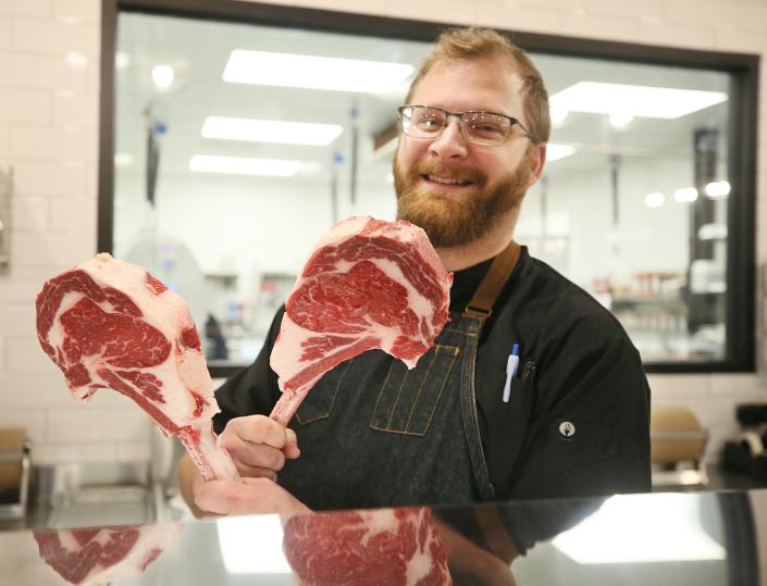 Drew Breece, director of operations at The Farmer&#39;s Rail Hudson, shows off steaks at the store and restaurant.