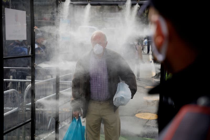 Albanian people are being disinfected before entering a market, as Albanian authorities take measures to stop the spread of the coronavirus disease (COVID-19) in Tirana