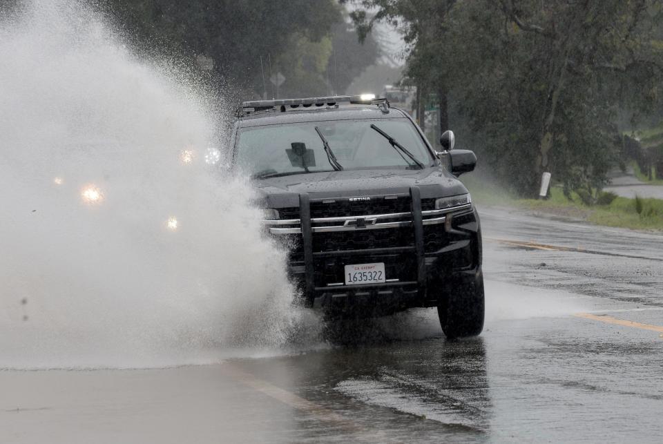 Cars go through puddles on Woodland Avenue and Highway 33 on Friday.