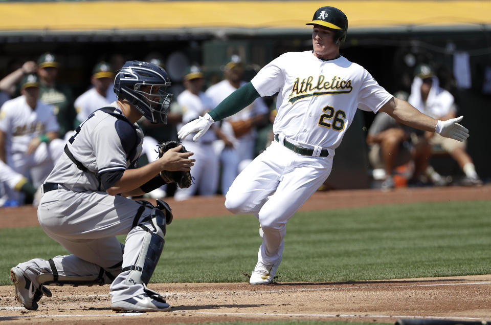 Oakland Athletics' Matt Chapman (26) slides toward New York Yankees catcher Gary Sanchez to score during the first inning of a baseball game in Oakland, Calif., Monday, Sept. 3, 2018. (AP Photo/Jeff Chiu)