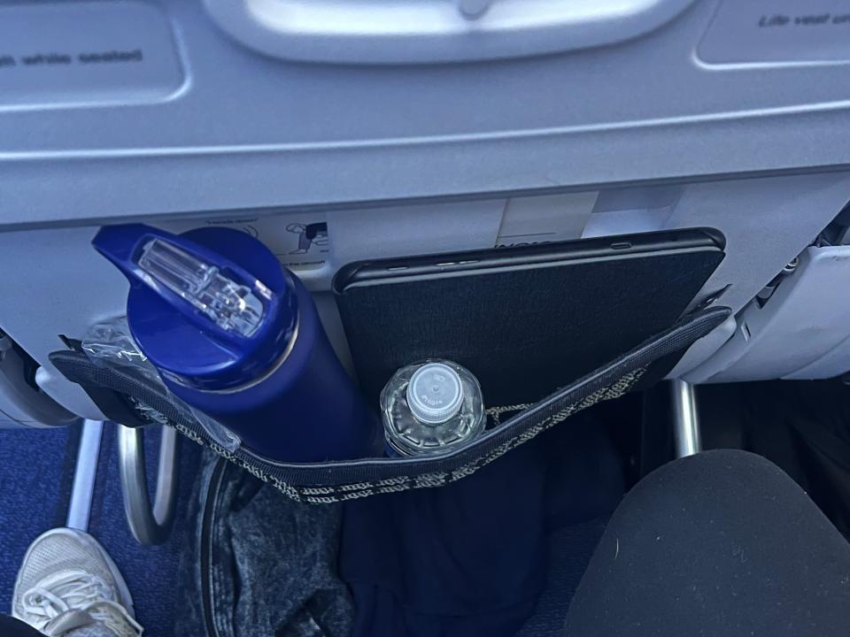 The seatback pocket with a water bottle and Kinde inside.