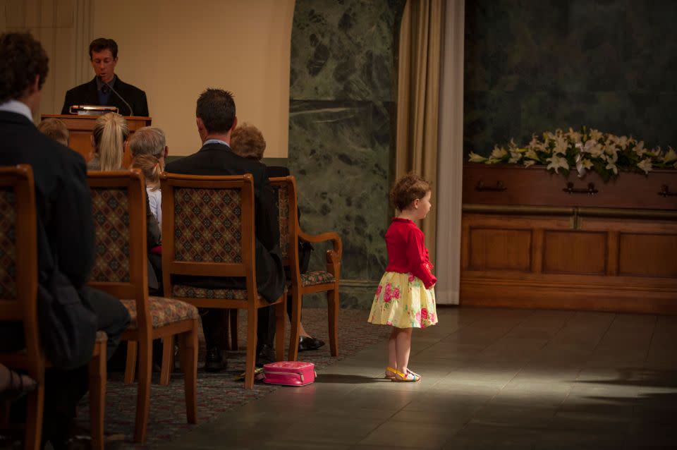 A little girl is caught in a ray of light at a funeral. Source: Supplied/John Slaytor.