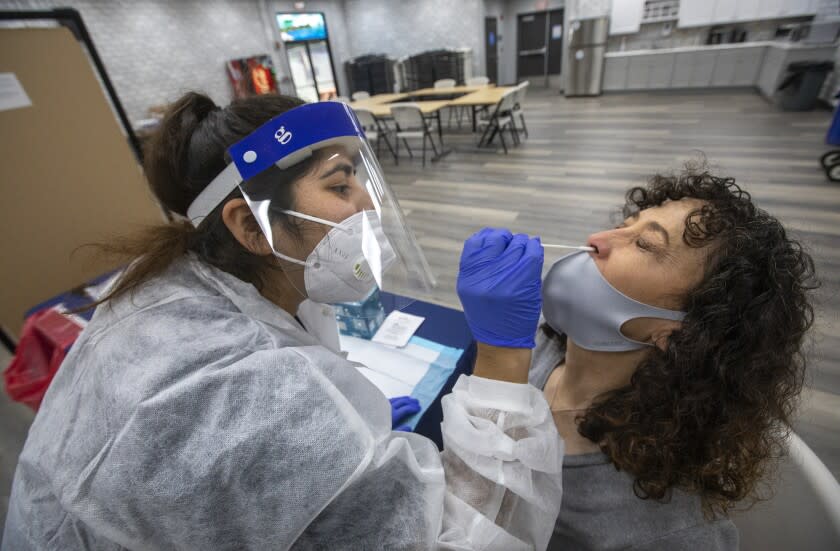 CALABASAS, CA - SEPTEMBER 02, 2020: Laura Duggan, right, office assistant at Lupin Hill Elementary School in Calabasas, is given a nasopharyngeal swab test to detect COVID-19 by phlebotomist Jessica Garcia at Arthur E. Wright Middle School in Calabasas. Las Virgenes School District employees on a voluntary basis were given a nasopharyngeal swab test to detect COVID-19 and also had their blood drawn to have it tested for antibodies to determine if they have had the coronavirus infection within the last 2 months. (Mel Melcon / Los Angeles Times)