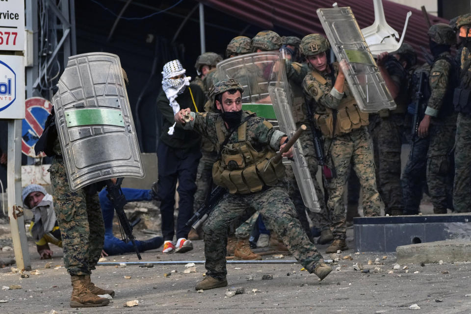 A Lebanese army soldier throws stones towards protesters during a demonstration, in solidarity with the Palestinian people in Gaza, near the U.S. embassy in Aukar, a northern suburb of Beirut, Lebanon, Wednesday, Oct. 18, 2023. Hundreds of angry protesters are clashing with Lebanese security forces in the Lebanese suburb Aukar near the United States Embassy. (AP Photo/Hassan Ammar)