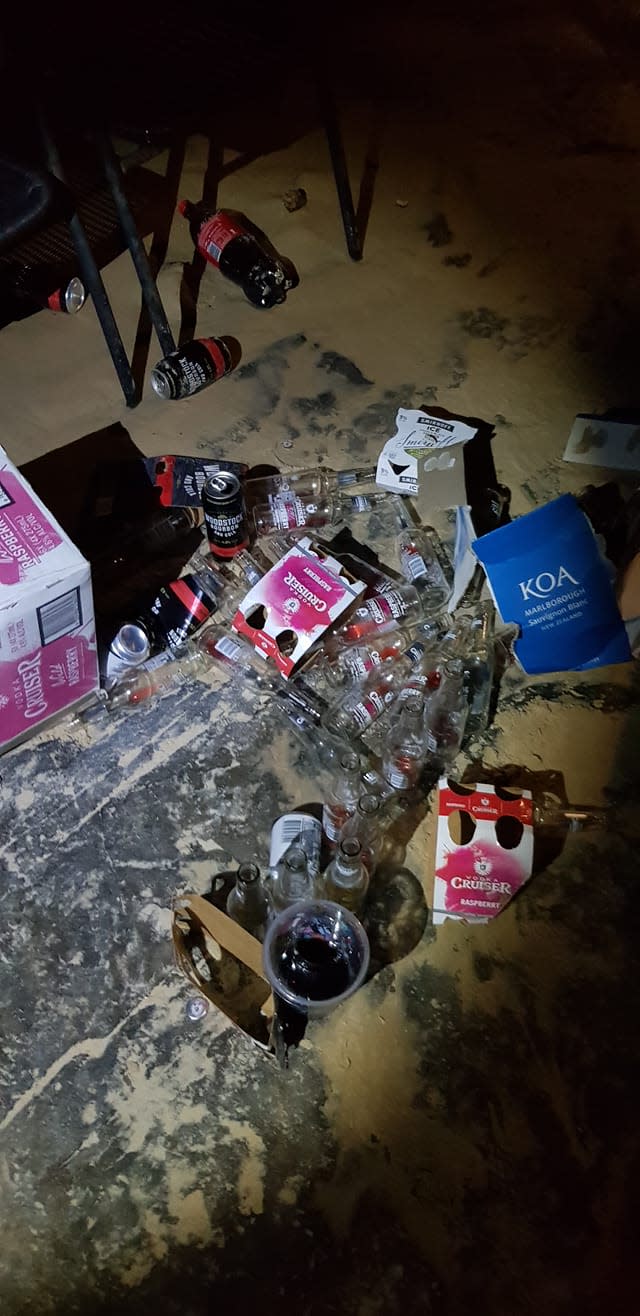 Empty vodka bottles and cans are seen on a beach at Noosa.