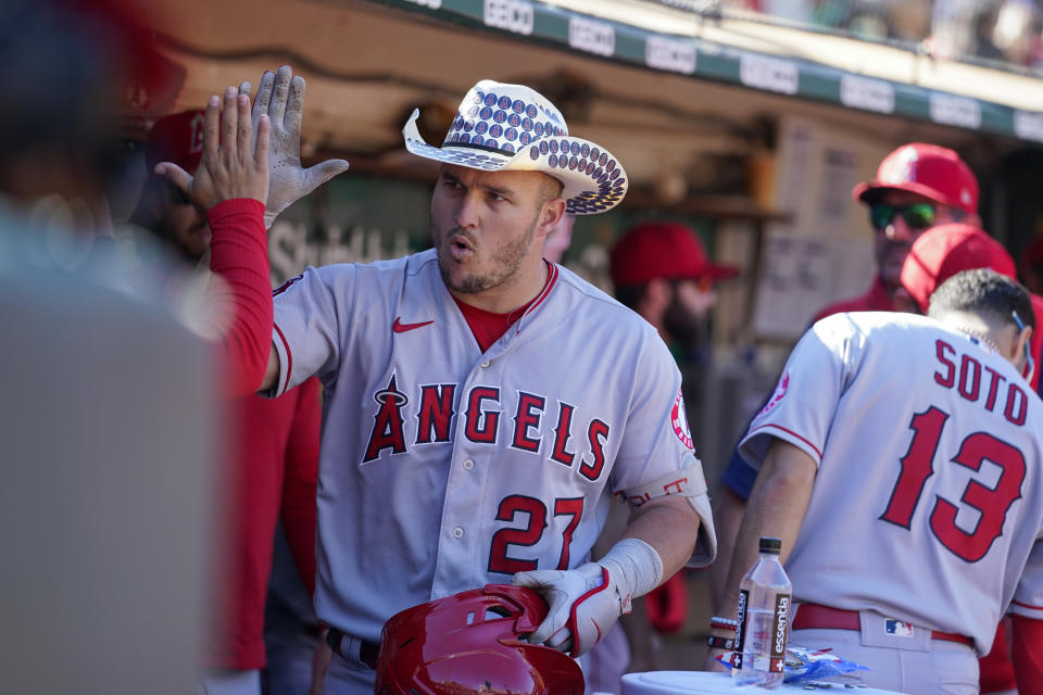 Los Angeles Angels' Mike Trout (27) celebrates with teammates in the dugout after hitting a solo home run against the Oakland Athletics during the eighth inning of a baseball game in Oakland, Calif., Wednesday, Oct. 5, 2022. (AP Photo/Godofredo A. Vásquez)
