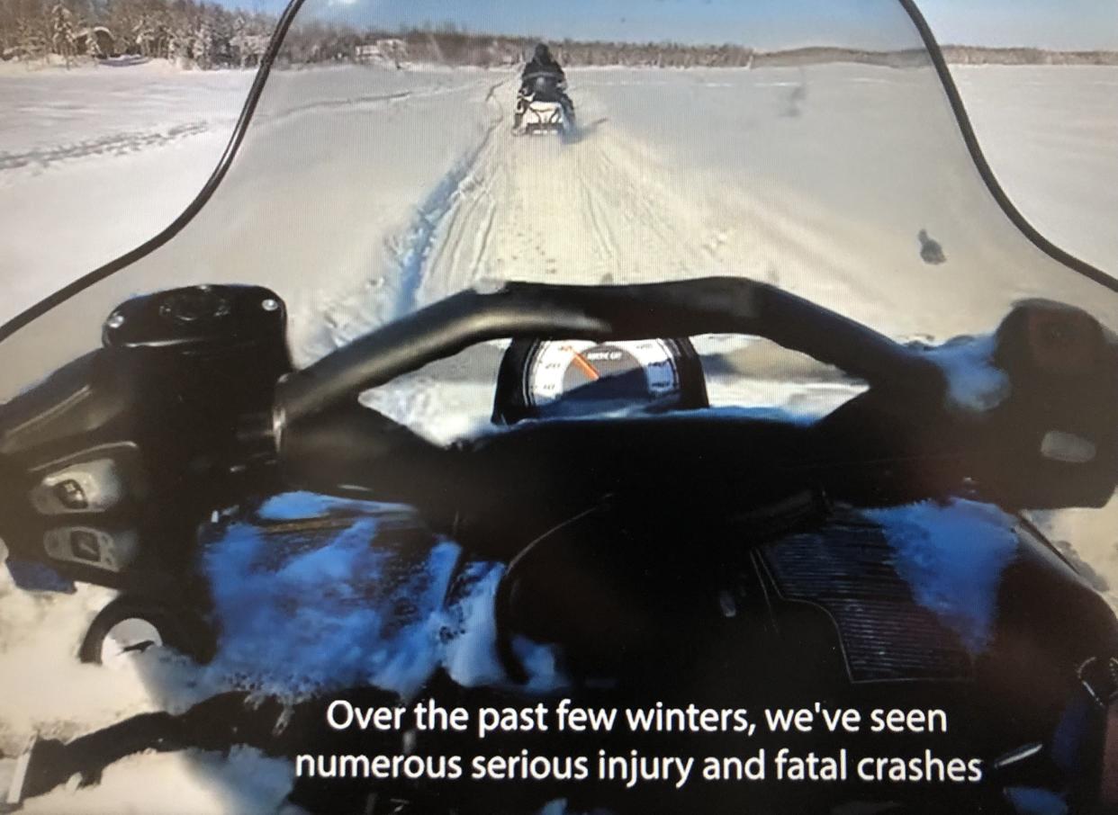 A snowmobile is seen riding behind another one in this scene from the Michigan Department of Natural Resources' new video on how to "lead right."