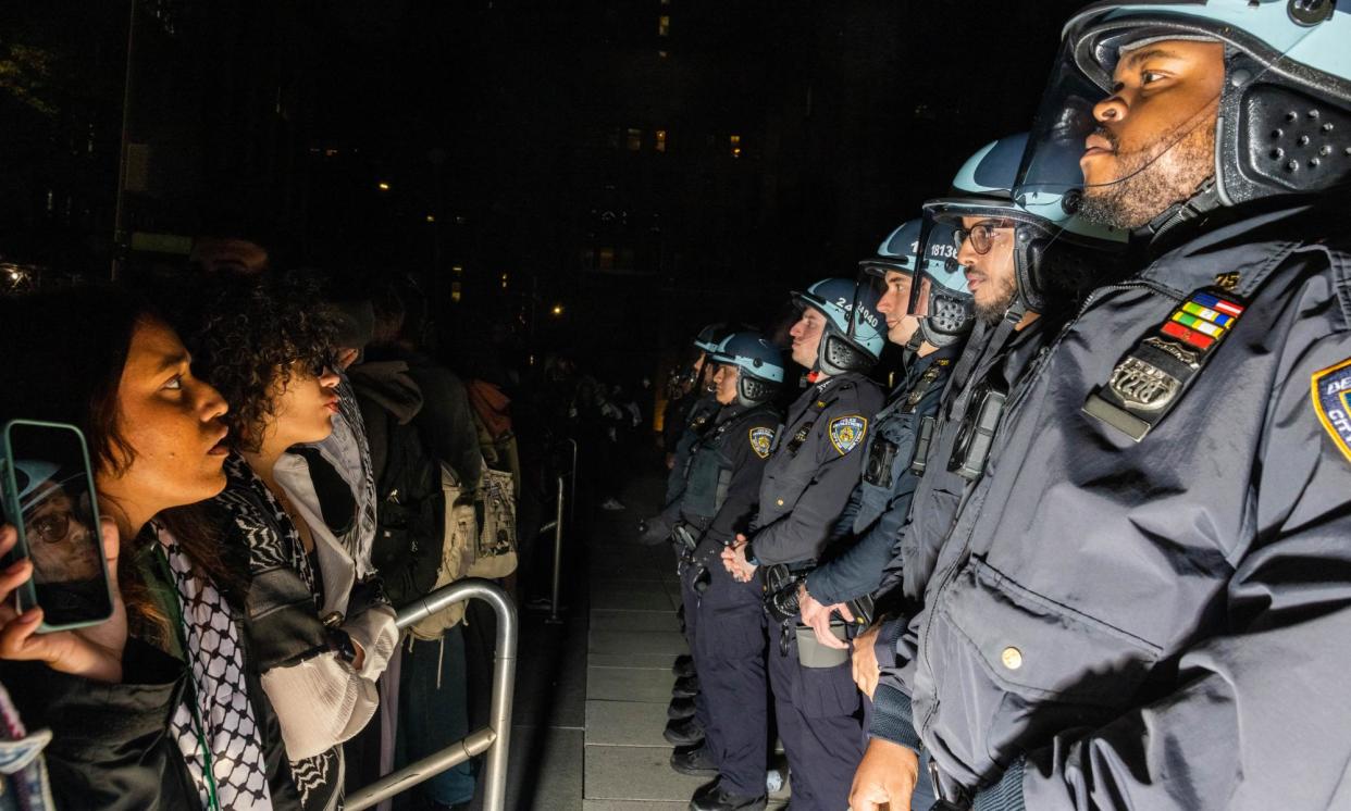 <span>Pro-Palestinian students and activists face police officers as they protest the Israel-Gaza war on the campus of New York University on Monday.</span><span>Photograph: Alex Kent/AFP/Getty Images</span>