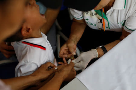 A child cries as he has a blood test sample taken during a health program of the NGO "Comparte por una vida" (Share for a life) at La Frontera school in Cucuta, Colombia February 5, 2019. Picture taken February 5, 2019. REUTERS/Marco Bello