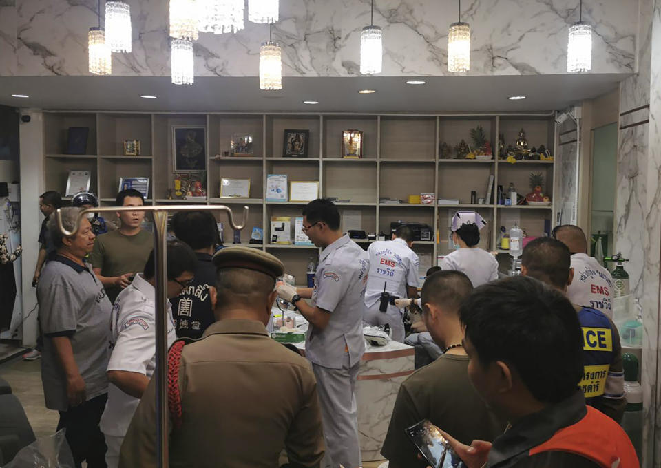 Security officers inspect the scene of a shooting in Bangkok, Thailand, Tuesday, Feb. 18, 2020. Gun violence has struck again at a shopping mall in Thailand, where a man in the nation's capital Bangkok on Tuesday shot dead one woman working at a beauty clinic and wounded another. The motive for the shooting was believed to be jealousy, and the suspected shooter escaped from the scene and remained at large several hours later. (Pho Koo 19 Volunteer, Ruam Duay Chuay Kan charity radio network via AP)