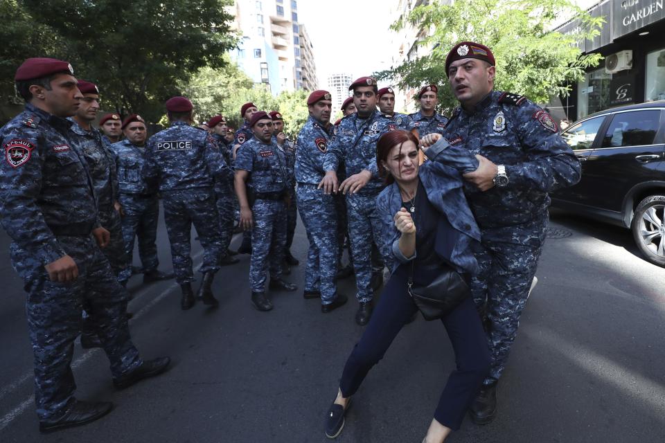 A police officer detains a demonstrator during a protest against Prime Minister Nikol Pashinyan in Yerevan, Armenia, Friday, Sept. 22, 2023. (Stepan Poghosyan/Photolure via AP)