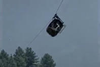 In this image taken from video, a cable car carrying six children and two adults dangles hundreds of meters above the ground in the remote Battagram district, Khyber Pakhtunkhwa, Pakistan on Tuesday, Aug. 22, 2023. The cable car malfunctioned, trapping the occupants for hours before rescuers arrived in helicopters to try to free them. (AP Photo)
