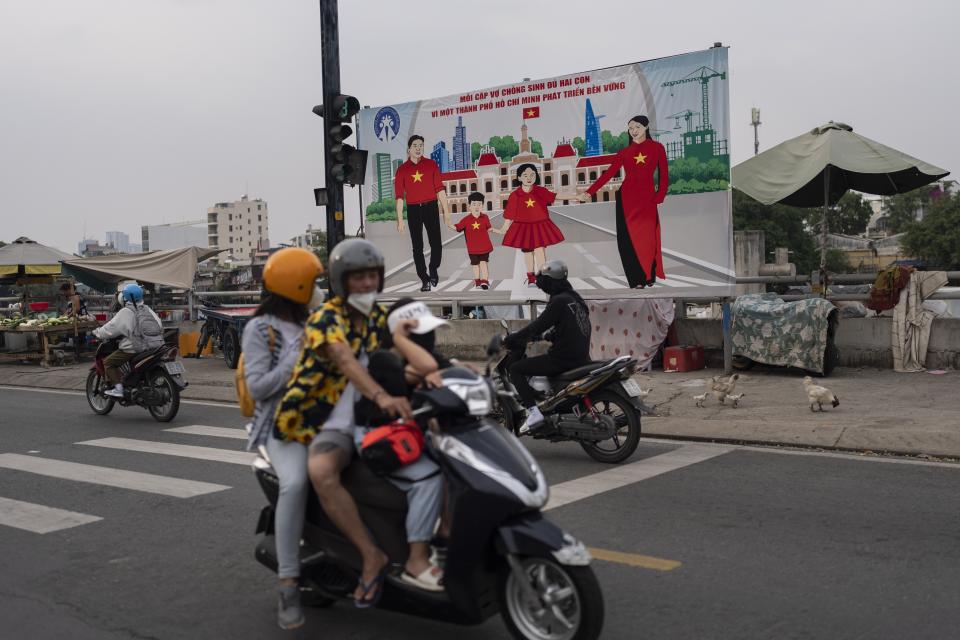 A billboard campaigning for each family to have two children in an effort to improve the birth rate stands along the street in Ho Chi Minh City, Vietnam, Jan. 14, 2024. (AP Photo/Jae C. Hong)