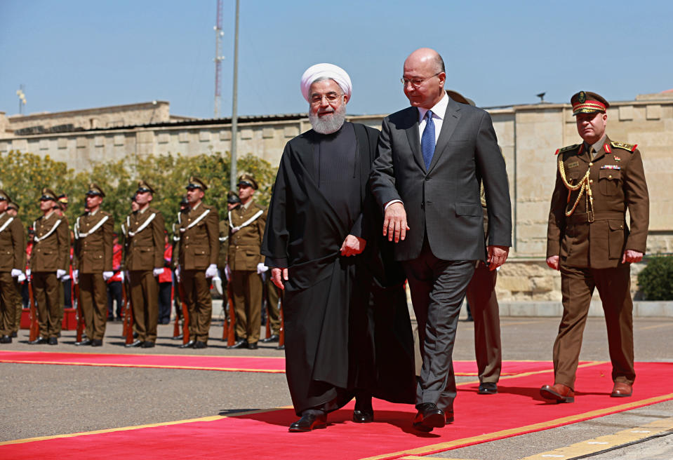 Iraqi President Barham Salih, center, walks with visiting Iranian President Hassan Rouhani, before their meeting at Salam Palace in Baghdad, Iraq, Monday, March 11, 2019. Rouhani is visiting Iraq, seeking to boost ties between the two neighboring states and possibly secure Iraq’s help in bypassing U.S. sanctions the Trump administration re-imposed last year. (AP Photo/Khalid Mohammed)