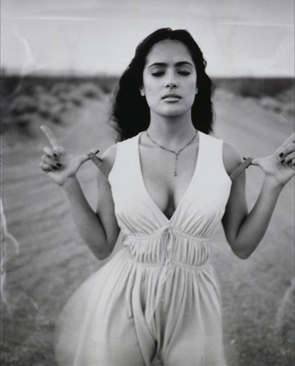 Salma Hayek holds her bra straps in a dress