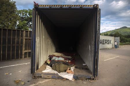 Anti-government protesters sleep inside a container which was used as a barricade by police forces in front of the parliament house, during the Revolution March in Islamabad September 3, 2014. REUTERS/Zohra Bensemra