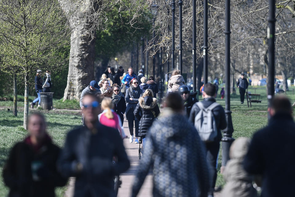 LONDON, ENGLAND  - MARCH 22: People are seen walking on Clapham Common on March 22, 2020 in London, United Kingdom. British Prime Minister Boris Johnson urged that people don't visit their parents this Mothering Sunday to curb the spread of COVID-19, which has killed 233 people in the UK.  (Photo by Peter Summers/Getty Images)