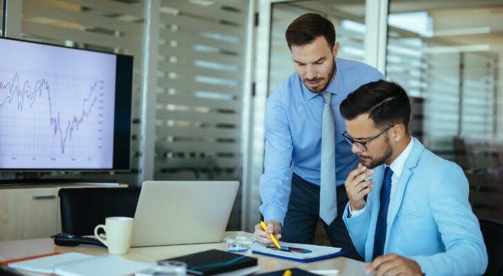 Two men discuss volume weighted average price data