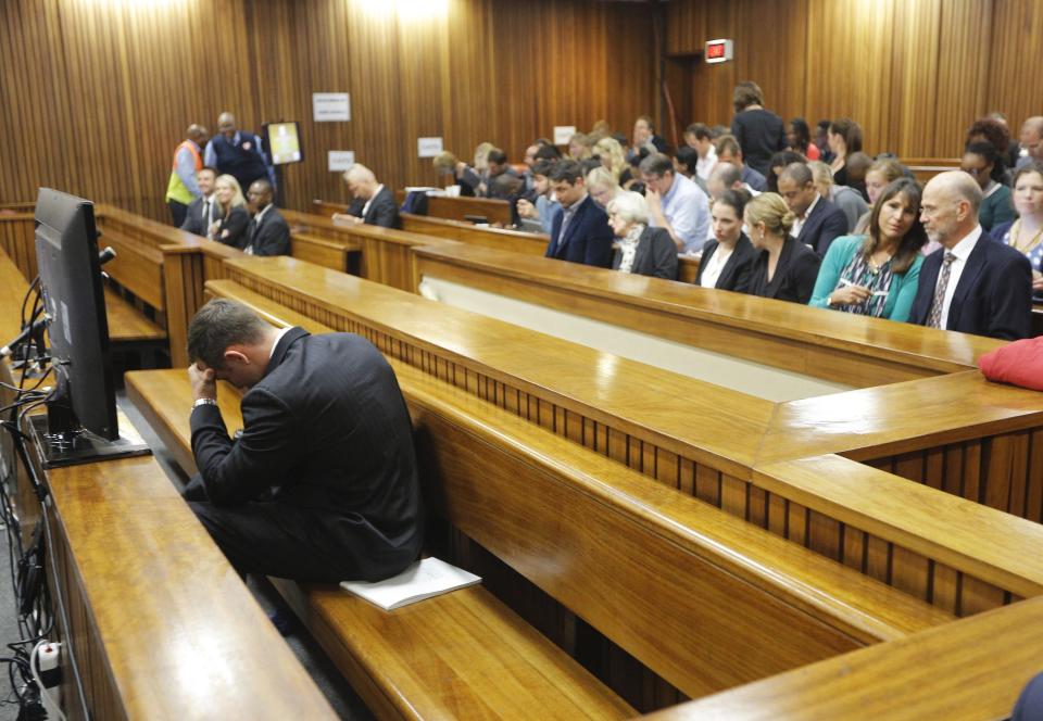 Oscar Pistorius sits in the dock ahead of the second day of the trial of the Olympic and Paralympic track star at the North Gauteng High Court in Pretoria, March 4, 2014. REUTERS/Kim Ludbrook/Pool (SOUTH AFRICA - Tags: SPORT ATHLETICS CRIME LAW TPX IMAGES OF THE DAY)