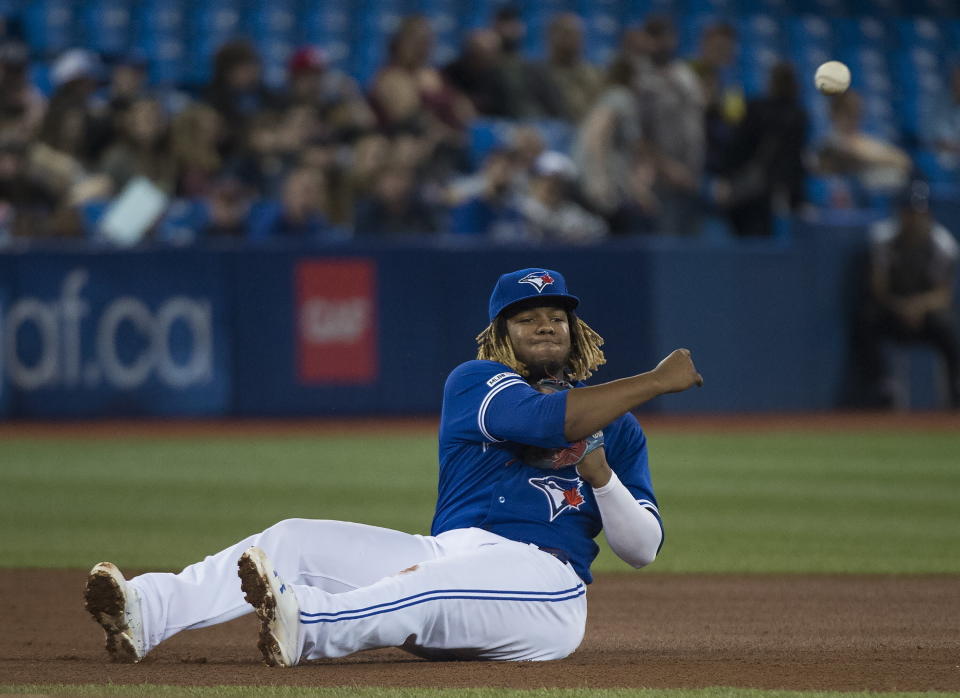 Toronto Blue Jays third baseman Vladimir Guerrero Jr. (27) makes a throw to first base to throw out Boston Red Sox's Rafael Devers during the fourth inning of a baseball game in Toronto on Thursday, May 23, 2019. (Nathan Denette/The Canadian Press via AP)