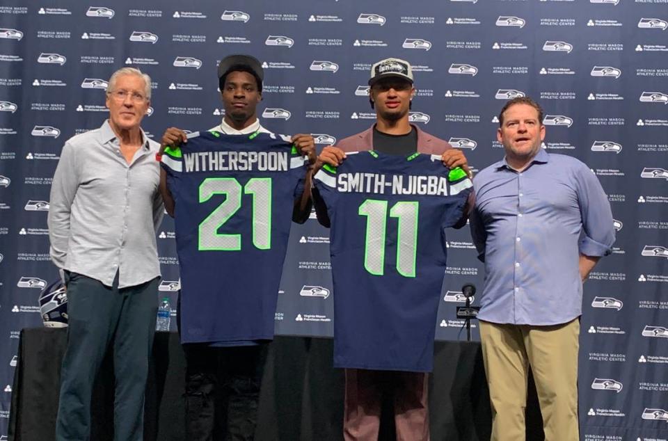 Pete Carroll, John Schneider flank cornerback Devon Witherspoon and wide receiver Jaxon Smith-Njigba on their introduction as newest Seahawks, including their new jerseys, on April 28, 2023, at the team’s facility in Renton. Seattle selected Witherspoon fifth and Smith-Njigba 20th in the first round of the NFL draft on April 27, 2023.