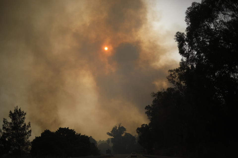 Smoke rises as a wildfire rages near Kibbutz Harel, Israel Thursday, May 23, 2019. Israeli police have ordered the evacuation of several communities in southern and central Israel as wildfires rage amid a major heatwave. (AP Photo/Ariel Schalit)